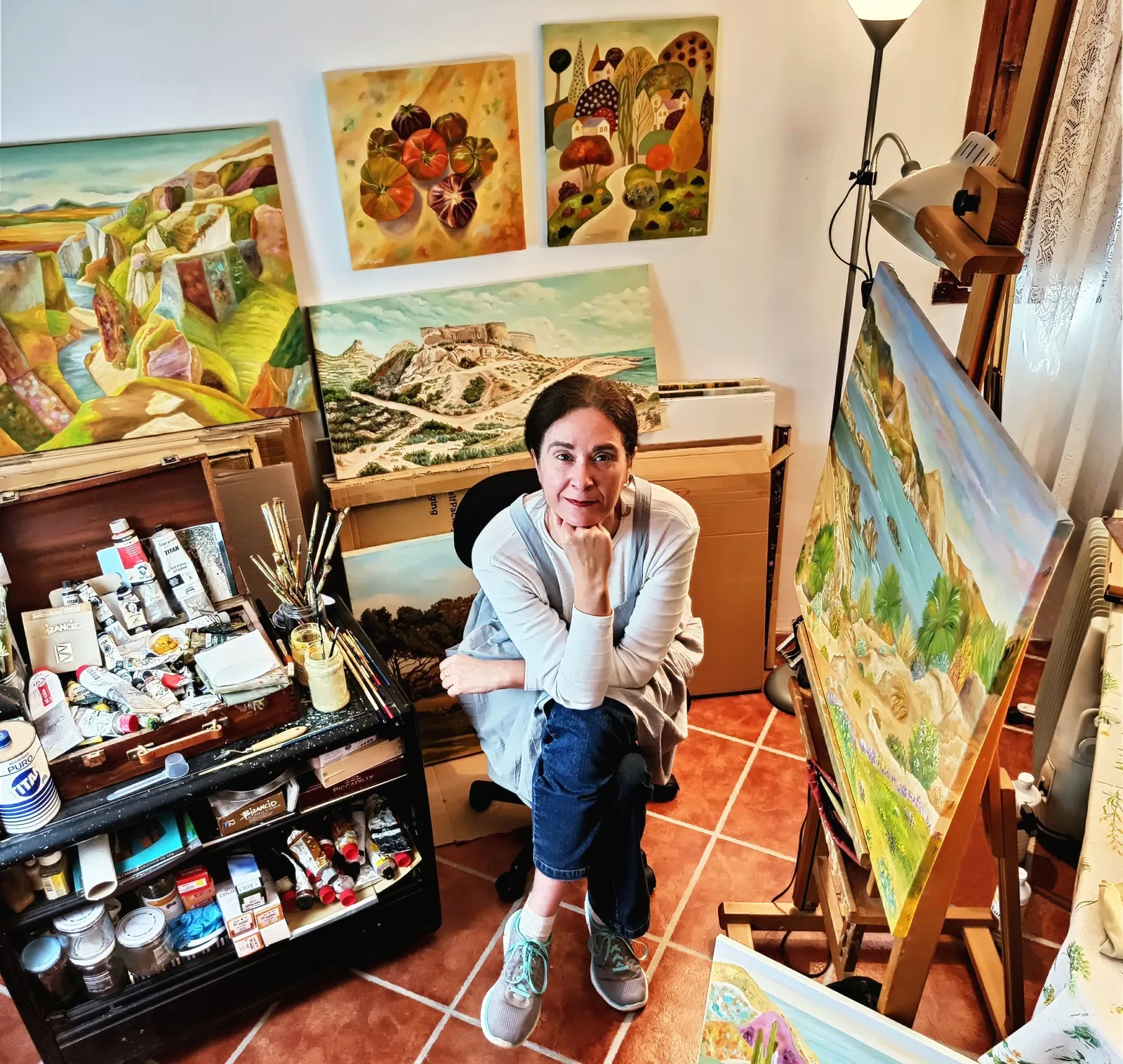 Angeles in her studio, surrounded by her paintings