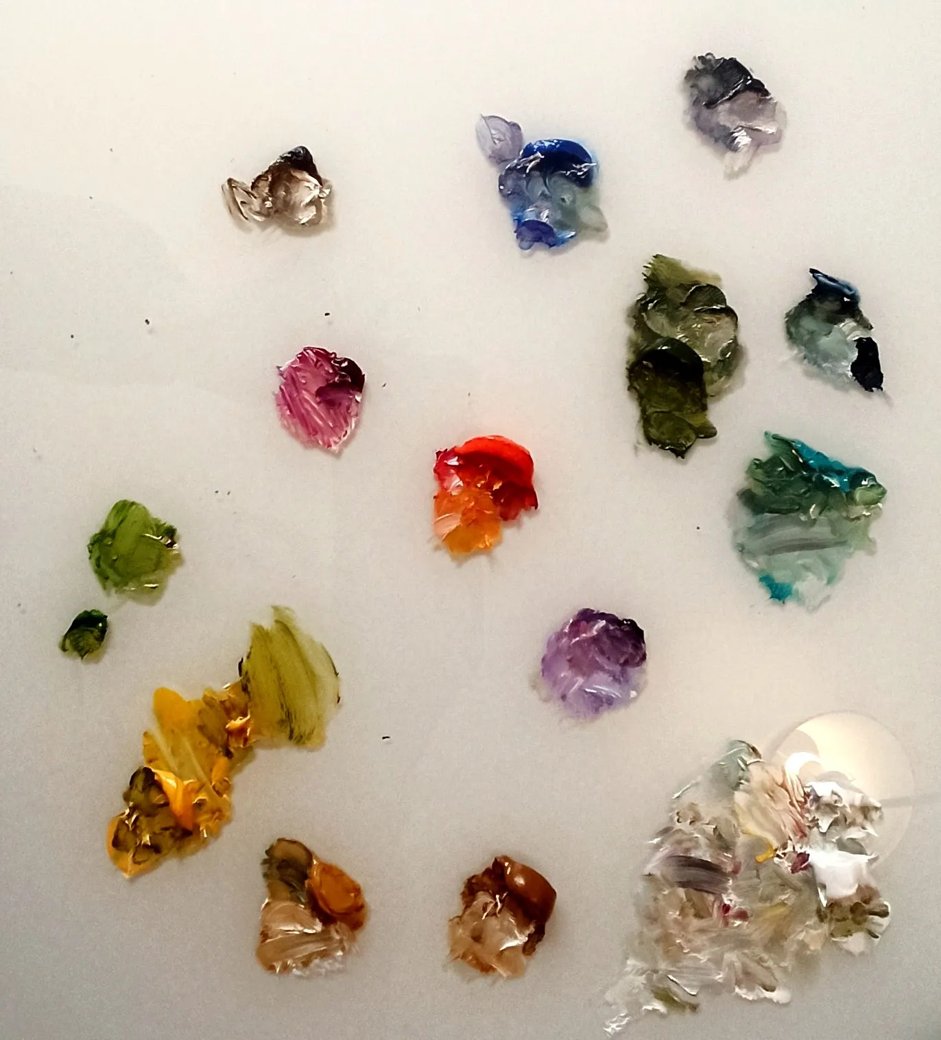 Dabs of oil paint in many colours on a white surface